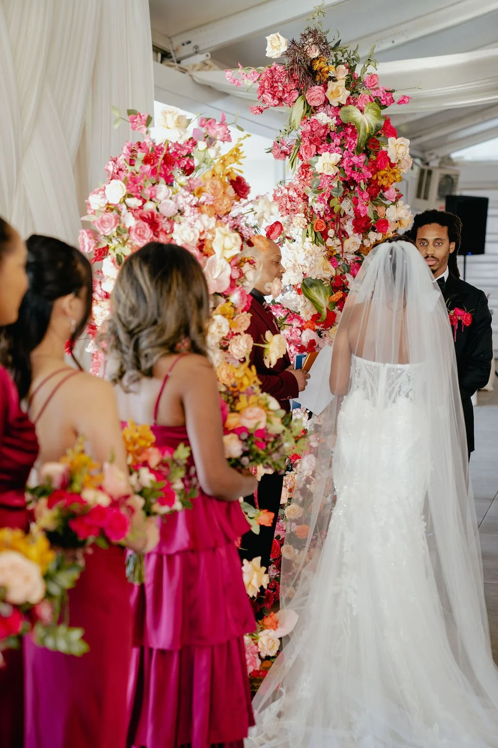 Bold Skyline Events SF wedding with rich deep raspberry, olive green, orange, burgundy, and pink wedding flowers. Featuring striking bridal and bridesmaid bouquets, ceremony florals, colorful reception centerpieces, lush aisle arrangements, and premi