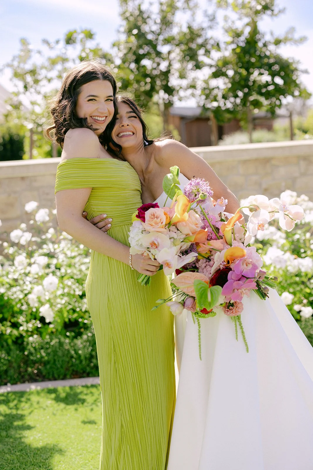 Vibrant Stanly Ranch wedding featuring bold orange, coral, fuchsia, and yellow wedding flowers. Explore lush bridal bouquets, ceremony floral installations, elevated aisle arrangements, and colorful reception centerpieces designed with premium blooms