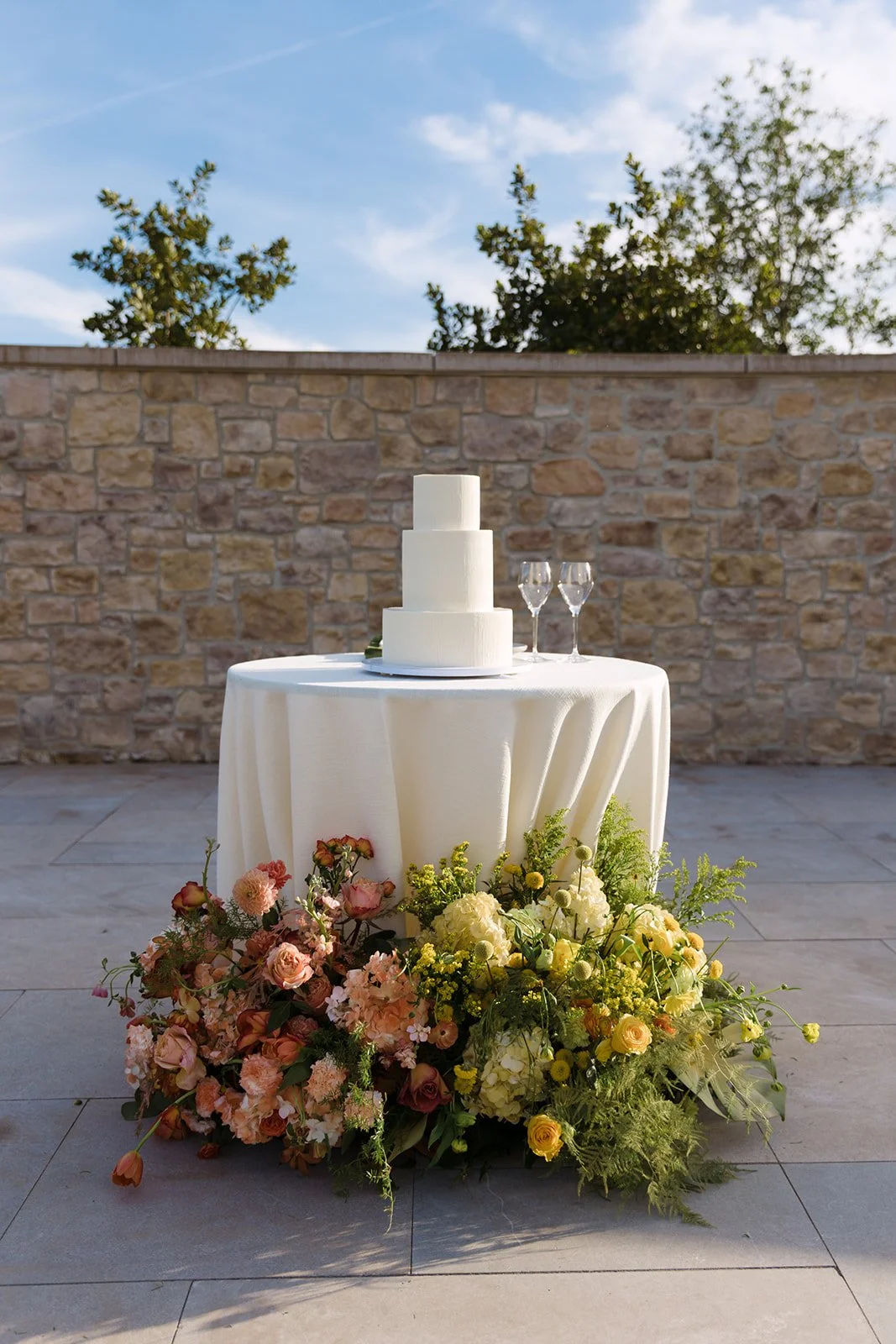 Vibrant Stanly Ranch wedding featuring bold orange, coral, fuchsia, and yellow wedding flowers. Explore lush bridal bouquets, ceremony floral installations, elevated aisle arrangements, and colorful reception centerpieces designed with premium blooms