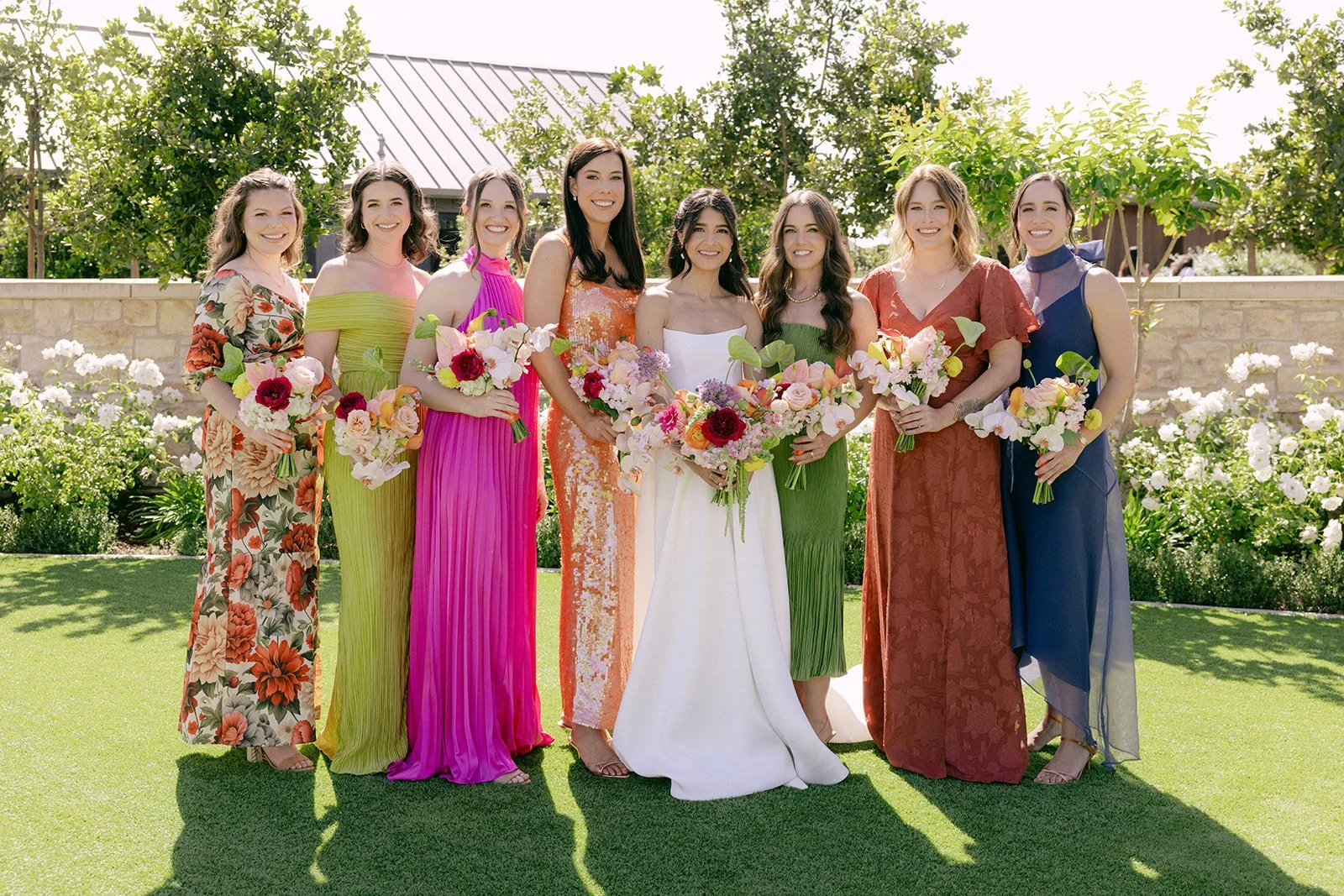 Vibrant Stanly Ranch wedding featuring bold orange, coral, fuchsia, and yellow wedding flowers. Explore lush bridal bouquets, ceremony floral installations, elevated aisle arrangements, and colorful reception centerpieces designed with premium blooms