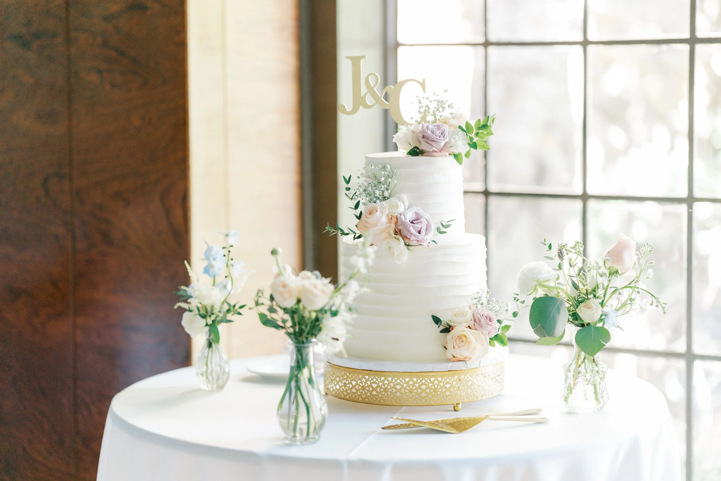 Wedding cake with floral accents, designed by a San Francisco-based florist, creating a charming display.