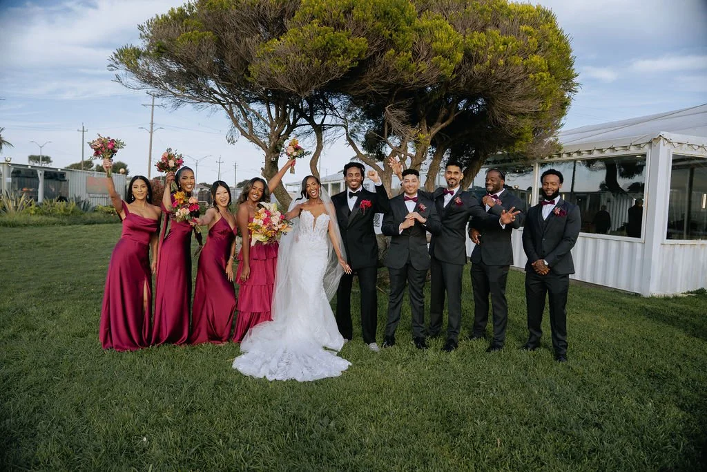 Bold Skyline Events SF wedding with rich deep raspberry, olive green, orange, burgundy, and pink wedding flowers. Featuring striking bridal and bridesmaid bouquets, ceremony florals, colorful reception centerpieces, lush aisle arrangements, and premi