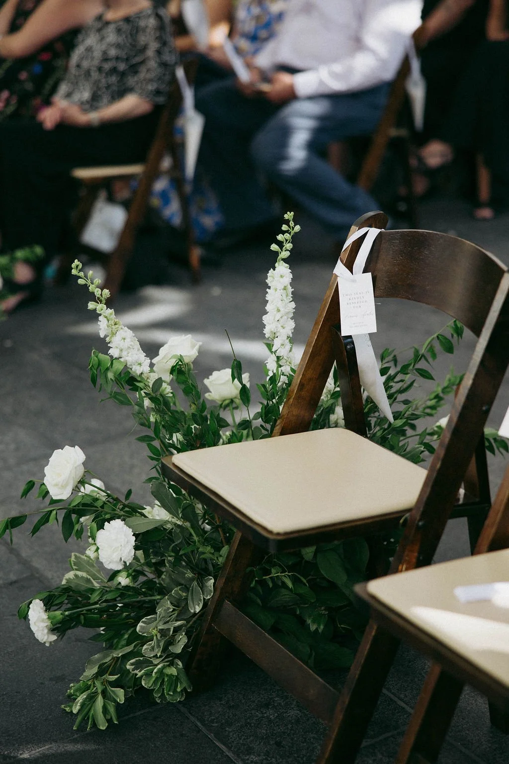 An elegant all-white palette transformed Blanco Urban Venue into a chic urban oasis for Bianca & John’s wedding. Lush roses, towering delphiniums, and touches of soft greenery lined the aisle, creating a bright, modern pathway toward the fireplace al