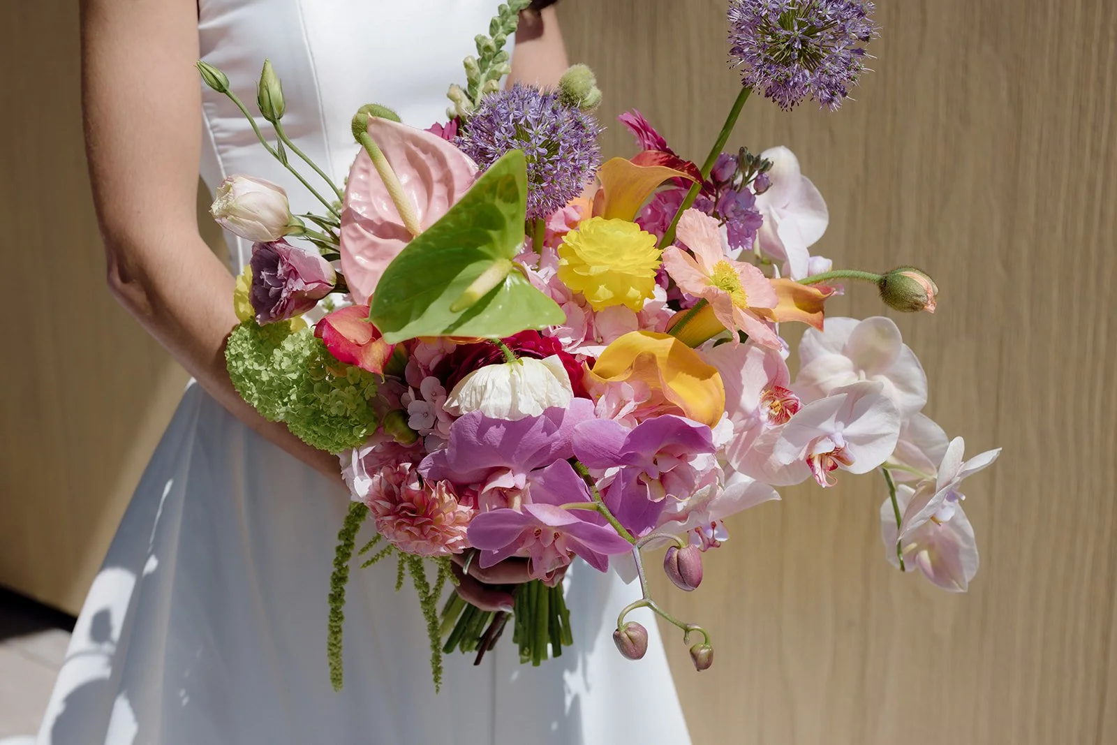 Vibrant Stanly Ranch wedding featuring bold orange, coral, fuchsia, and yellow wedding flowers. Explore lush bridal bouquets, ceremony floral installations, elevated aisle arrangements, and colorful reception centerpieces designed with premium blooms
