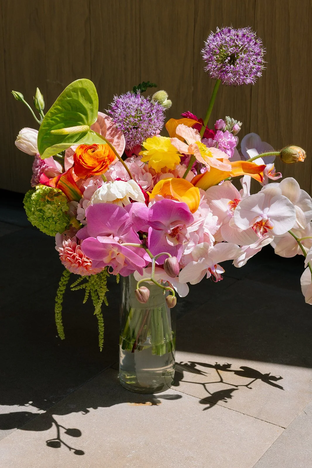 Vibrant Stanly Ranch wedding featuring bold orange, coral, fuchsia, and yellow wedding flowers. Explore lush bridal bouquets, ceremony floral installations, elevated aisle arrangements, and colorful reception centerpieces designed with premium blooms