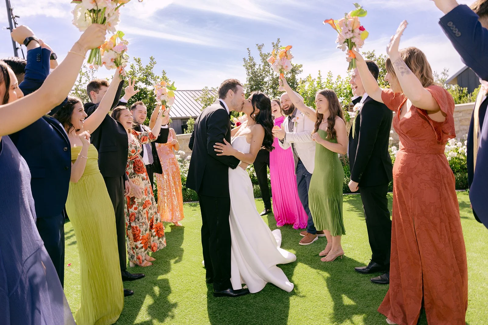 Vibrant Stanly Ranch wedding featuring bold orange, coral, fuchsia, and yellow wedding flowers. Explore lush bridal bouquets, ceremony floral installations, elevated aisle arrangements, and colorful reception centerpieces designed with premium blooms