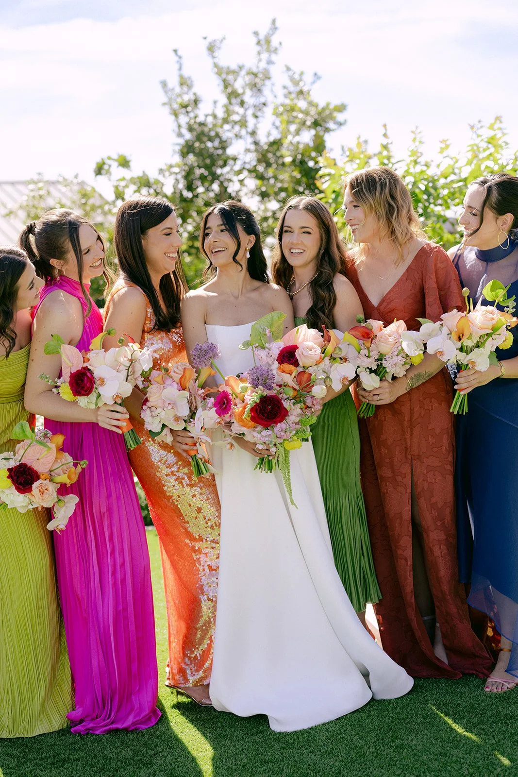 Vibrant Stanly Ranch wedding featuring bold orange, coral, fuchsia, and yellow wedding flowers. Explore lush bridal bouquets, ceremony floral installations, elevated aisle arrangements, and colorful reception centerpieces designed with premium blooms