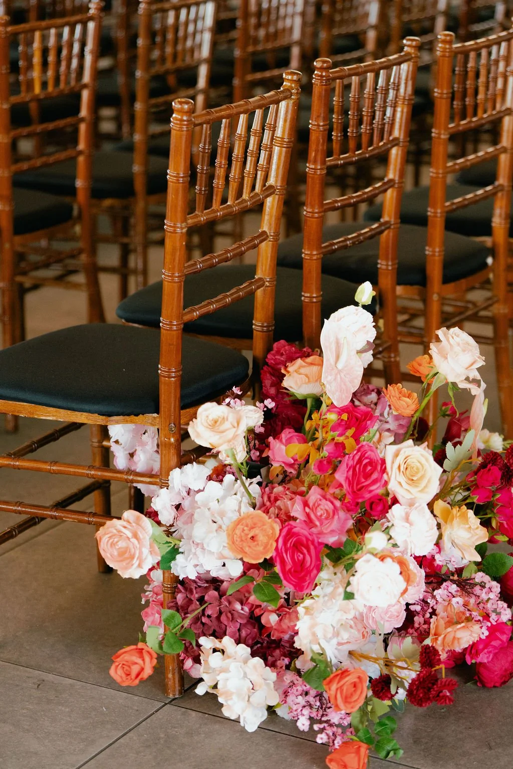 Bold Skyline Events SF wedding with rich deep raspberry, olive green, orange, burgundy, and pink wedding flowers. Featuring striking bridal and bridesmaid bouquets, ceremony florals, colorful reception centerpieces, lush aisle arrangements, and premi