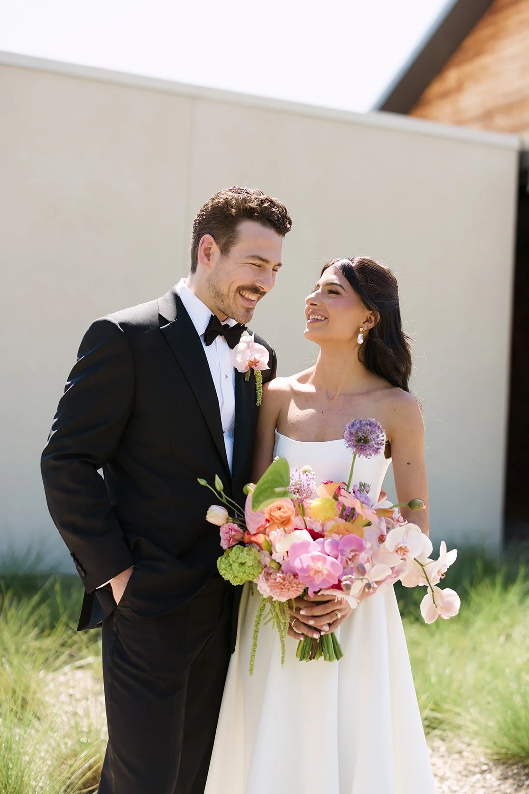 Vibrant Stanly Ranch wedding featuring bold orange, coral, fuchsia, and yellow wedding flowers. Explore lush bridal bouquets, ceremony floral installations, elevated aisle arrangements, and colorful reception centerpieces designed with premium blooms