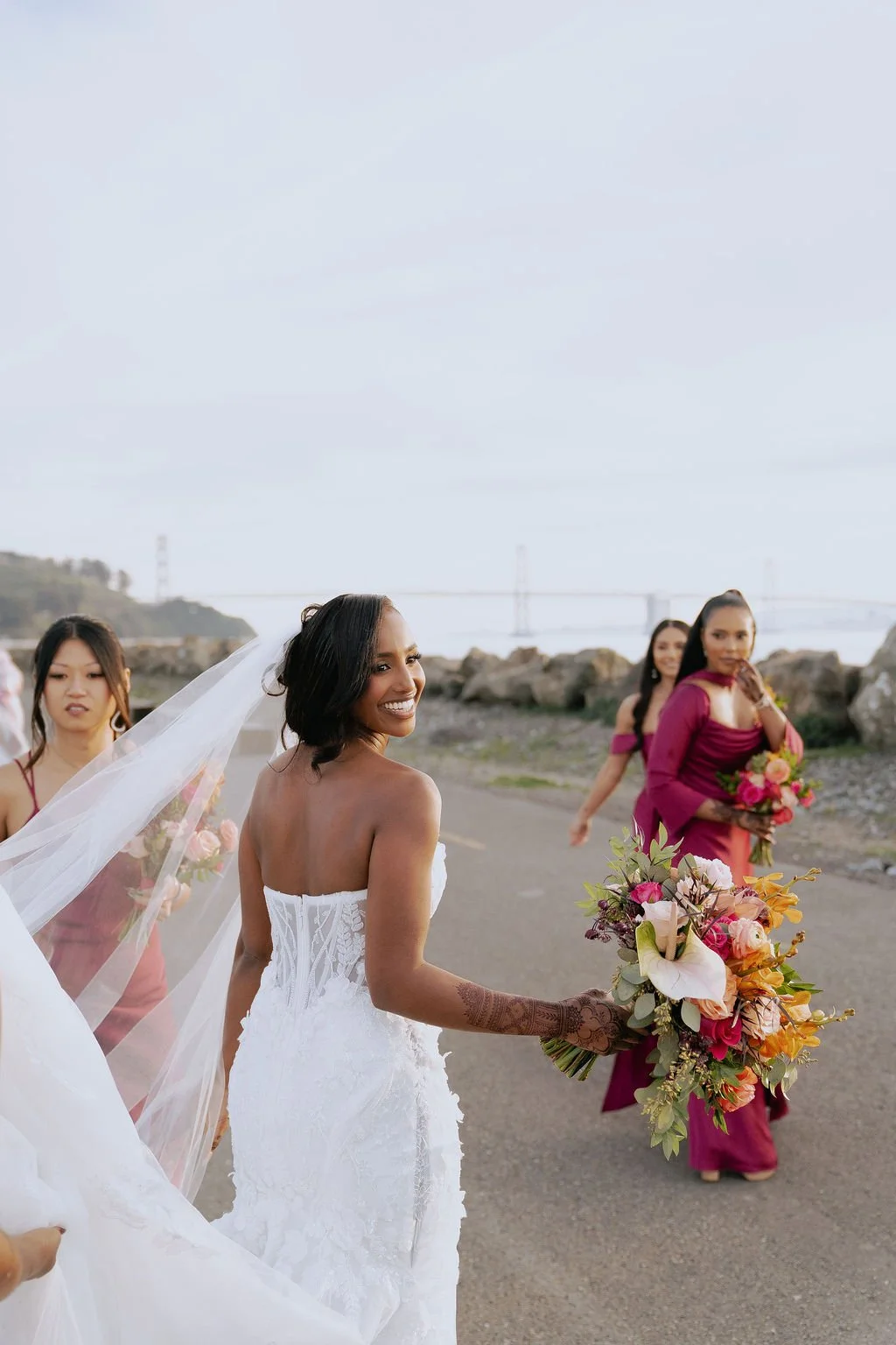 Bold Skyline Events SF wedding with rich deep raspberry, olive green, orange, burgundy, and pink wedding flowers. Featuring striking bridal and bridesmaid bouquets, ceremony florals, colorful reception centerpieces, lush aisle arrangements, and premi