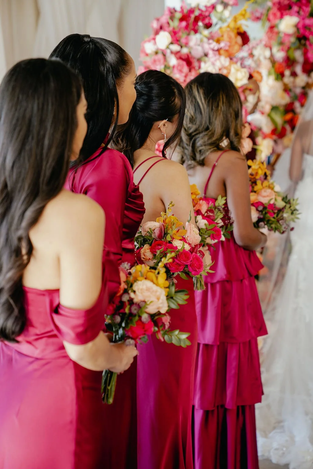 Bold Skyline Events SF wedding with rich deep raspberry, olive green, orange, burgundy, and pink wedding flowers. Featuring striking bridal and bridesmaid bouquets, ceremony florals, colorful reception centerpieces, lush aisle arrangements, and premi