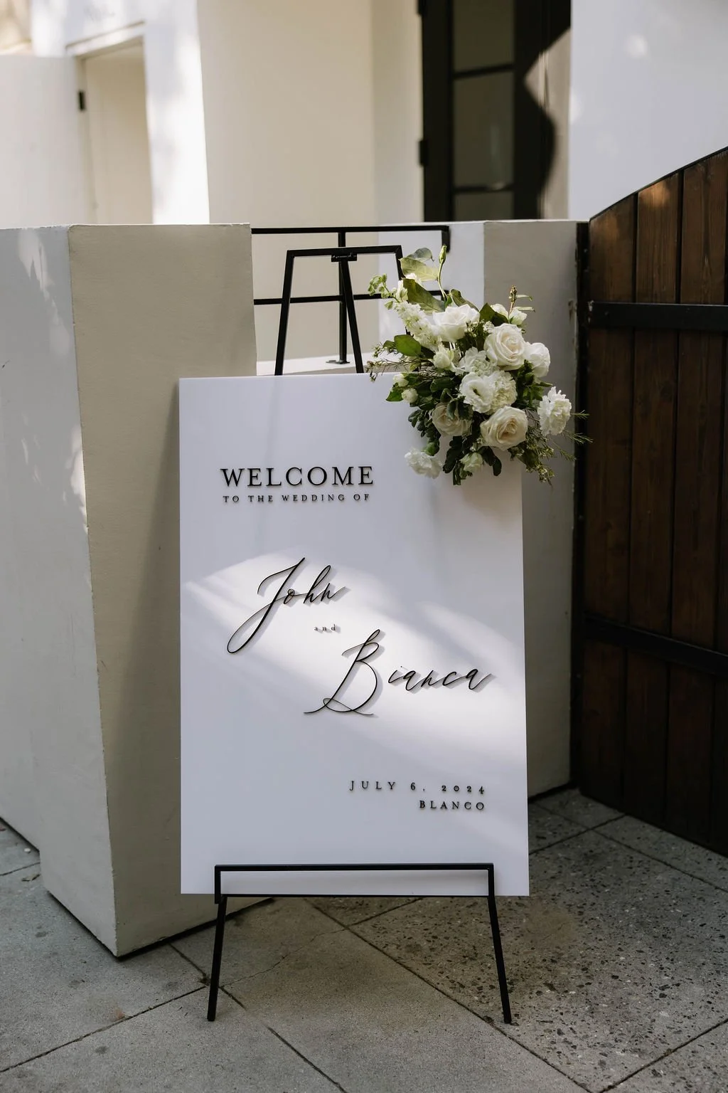 An elegant all-white palette transformed Blanco Urban Venue into a chic urban oasis for Bianca & John’s wedding. Lush roses, towering delphiniums, and touches of soft greenery lined the aisle, creating a bright, modern pathway toward the fireplace al