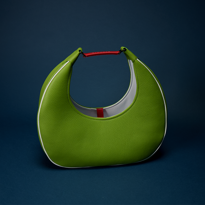 REINA Shoulder Bag in Mexi — green suede crescent silhouette with red and white Italian leather Duo detailing and gunmetal hardware, paired with the RINA La Chingona sneaker