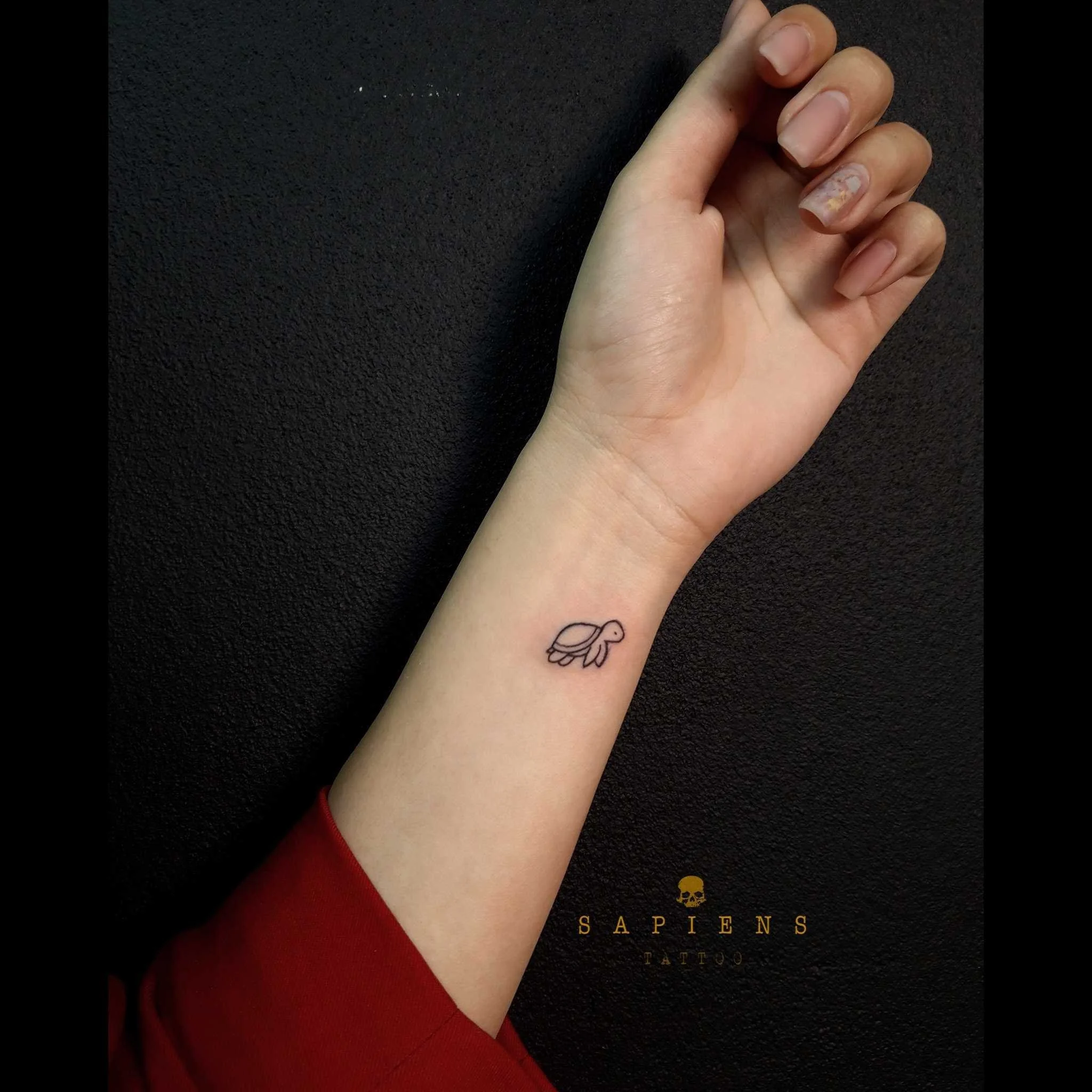 tatuaj mic la inchietura mainii pe antebrat interior cu o testoasa foarte mic facuta din linii simple