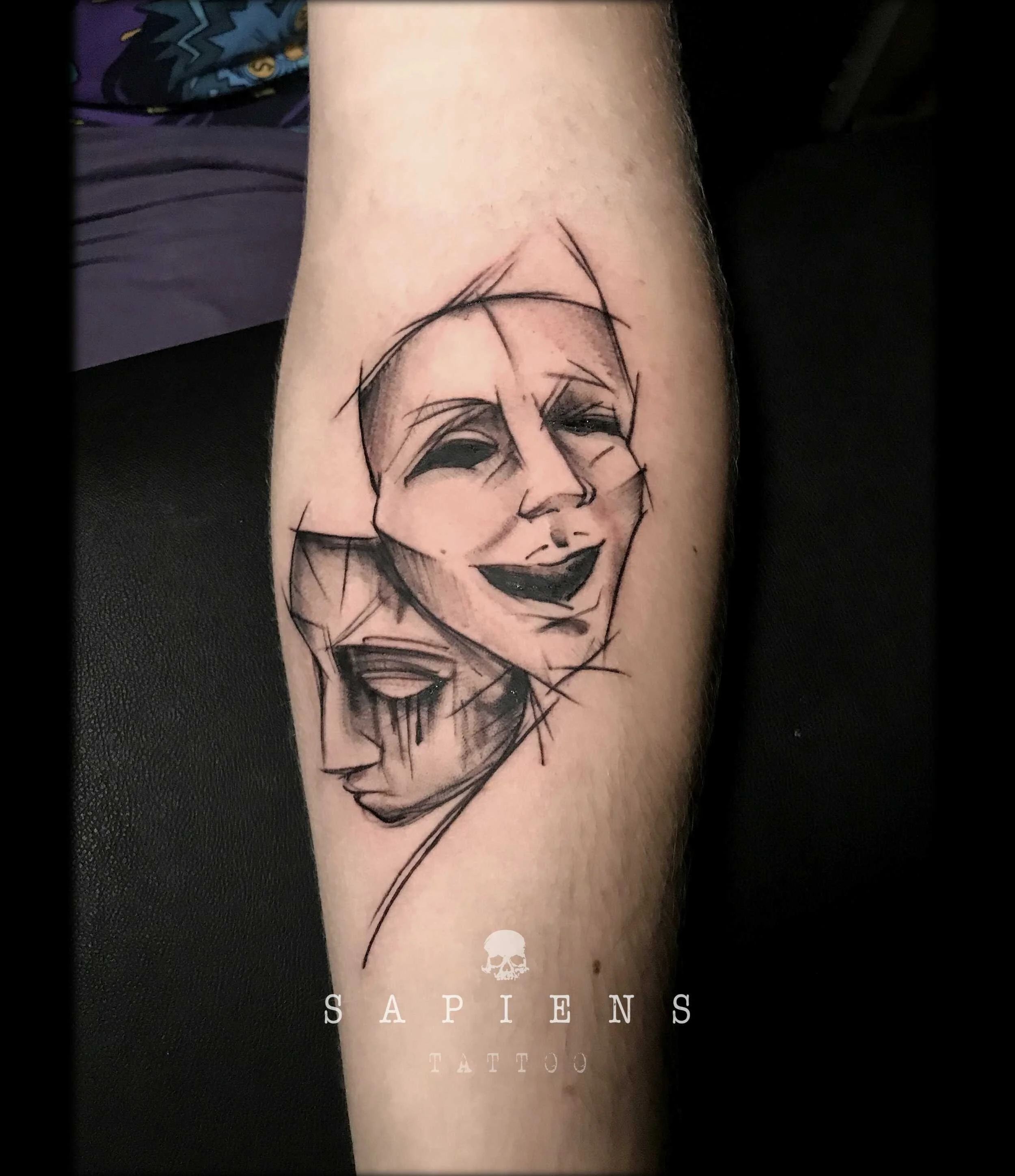 tatuaj pe antebrat cu celebrele masti de teatru una plange una rade