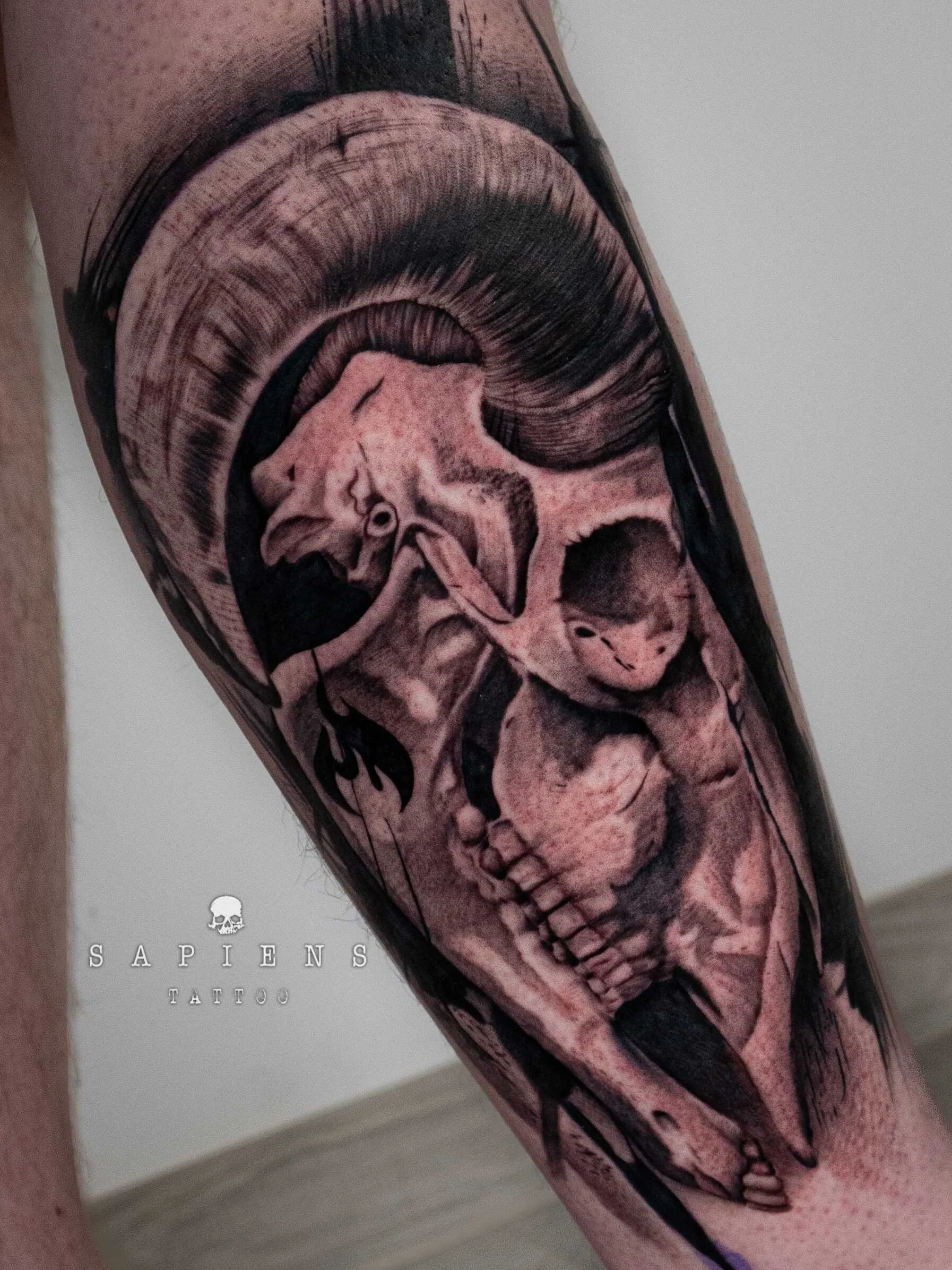 tatuaj pe gamba unui barbat cu un craniu de berbec in stil realistic