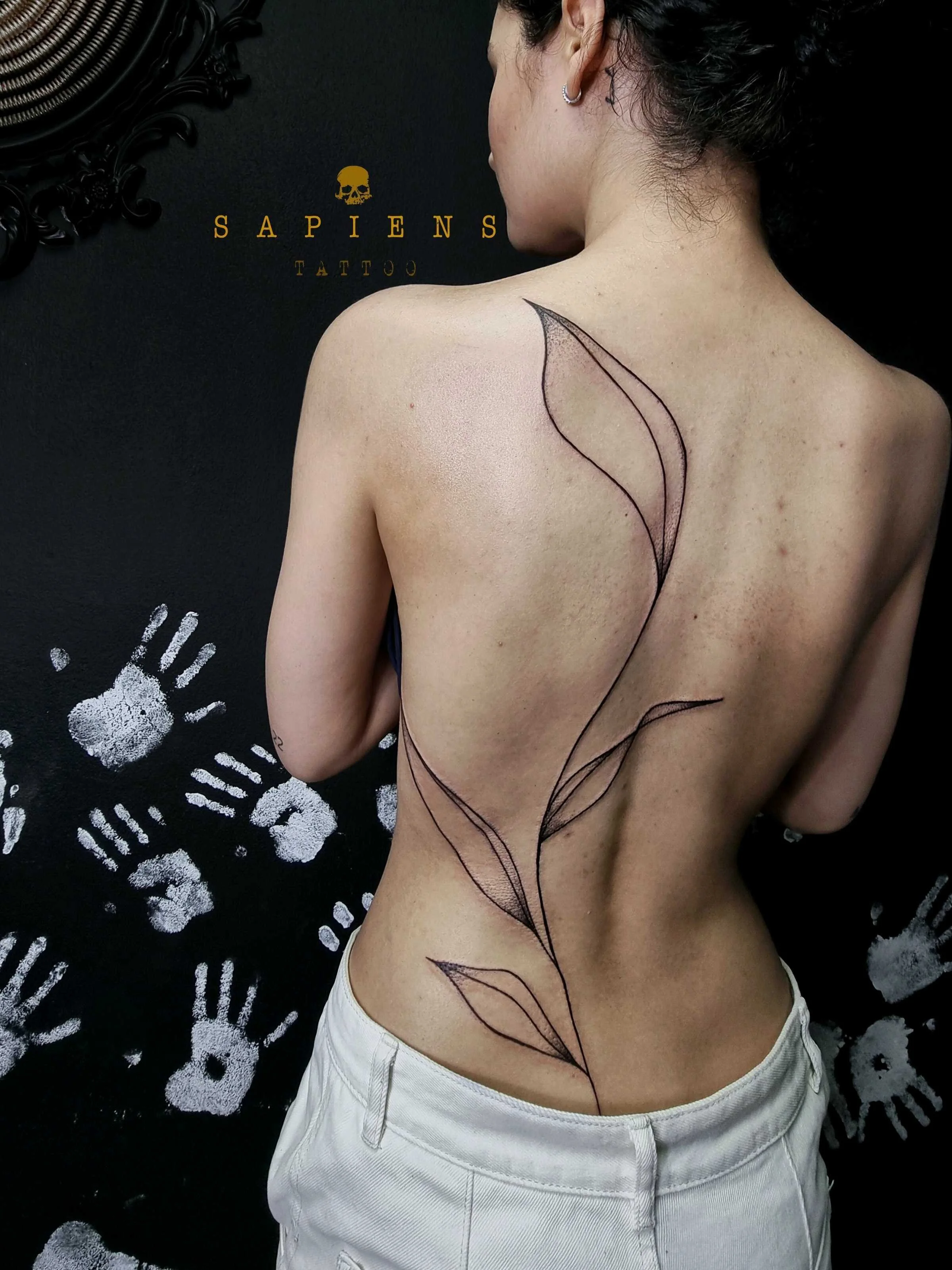 femeie tatuata pe spate cu linii subtiri