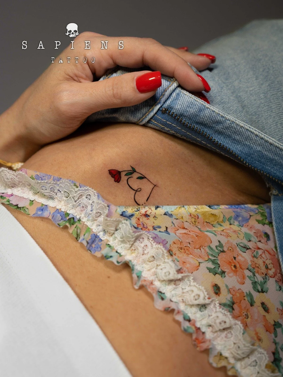 tatuaj pe linia lenjeriei cu o inimioara mici si un trandafir color rosu