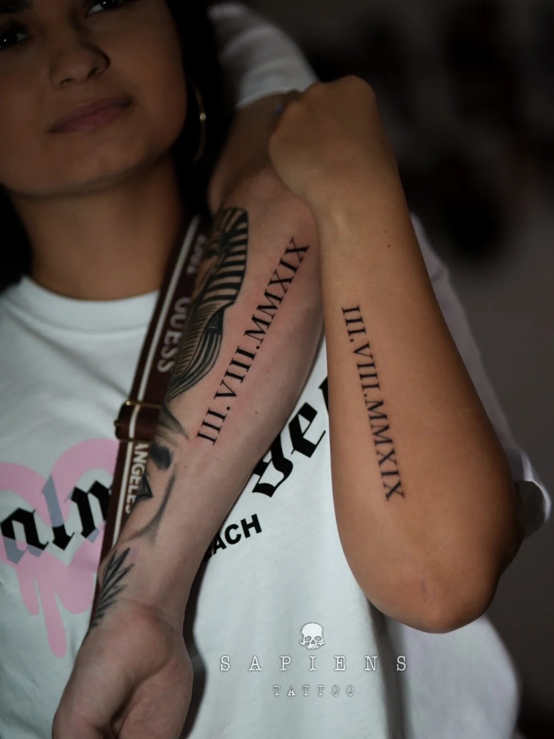 cuplu de femeie si barbat cu un tatuaj matching cu scris in cifre romane pe antebrat exterior