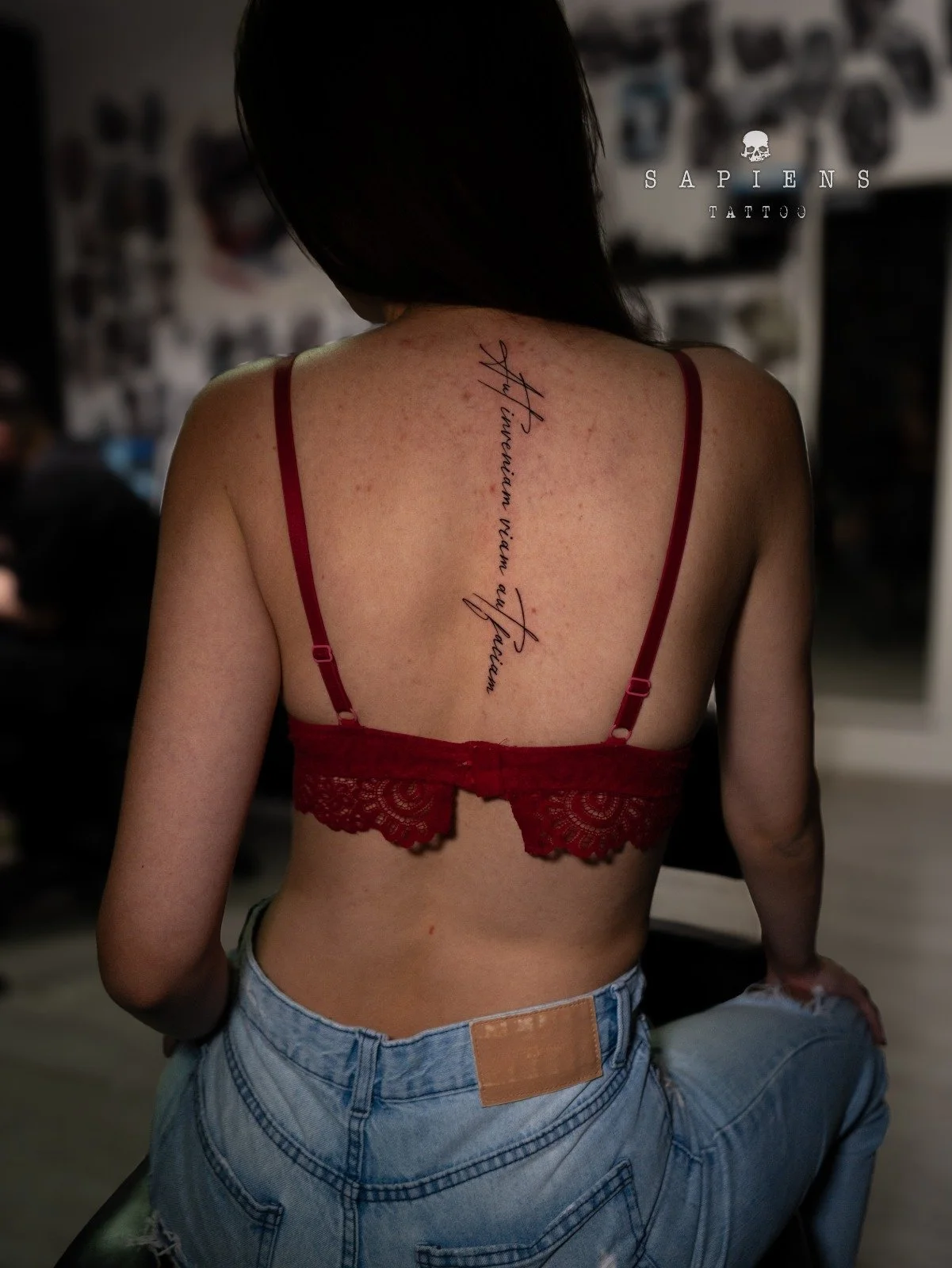 tatuaj cu scris pe coloana pentru femei cu un citat in limba latina scrisul este italic finut