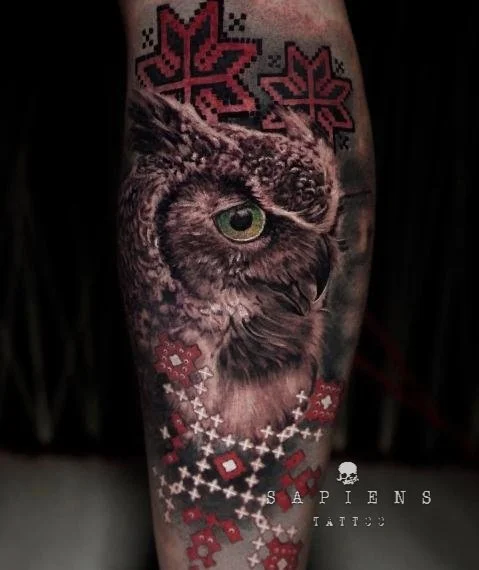 tatuaj pe picior gamba spate cu o bufnita in stil realistic si motive traditionale romanesti color