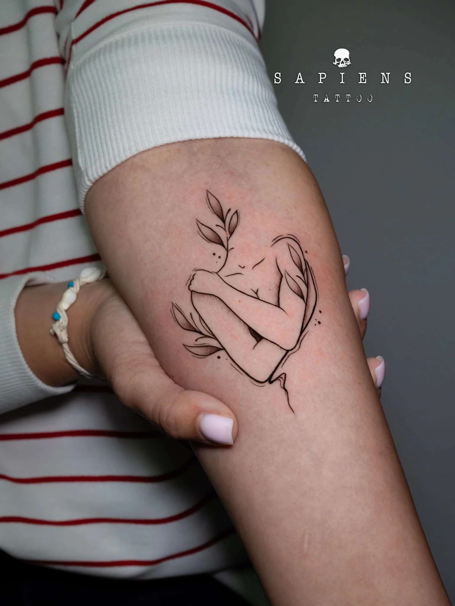 tatuaj din linii femeie ce se imbratiseaza singura