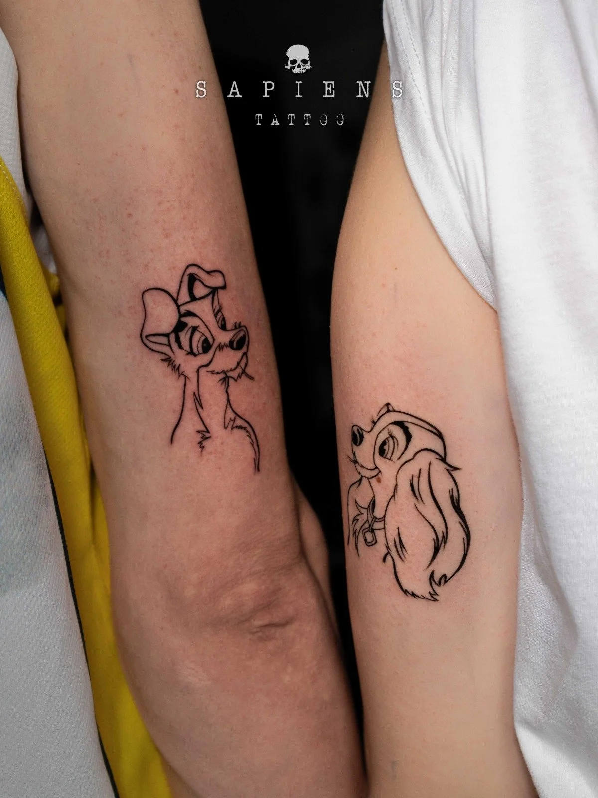 tatuaj simplu din linii cu personajele din desenul animat doamna si vagabondul