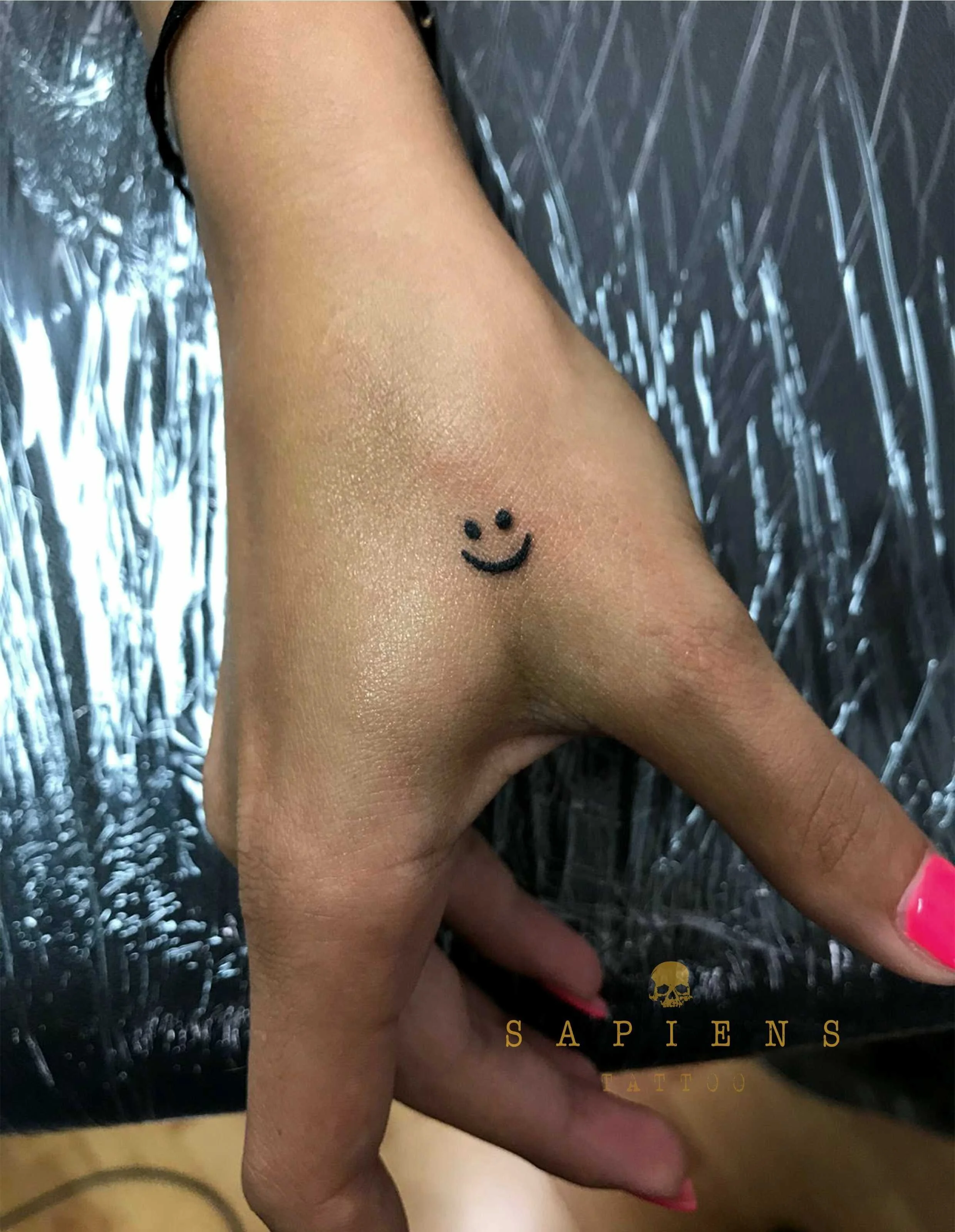 tatuaj mic cu un simley face pe mana