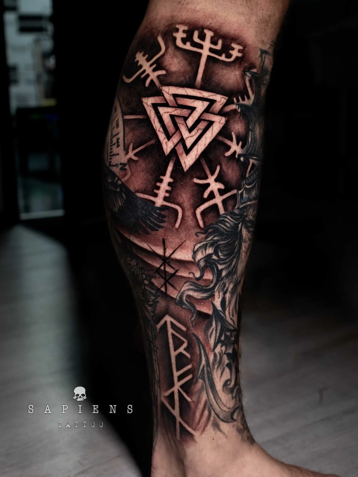 tatuaj mare pe toata gamba cu simboluri si rune vikinge pe fundal negru
