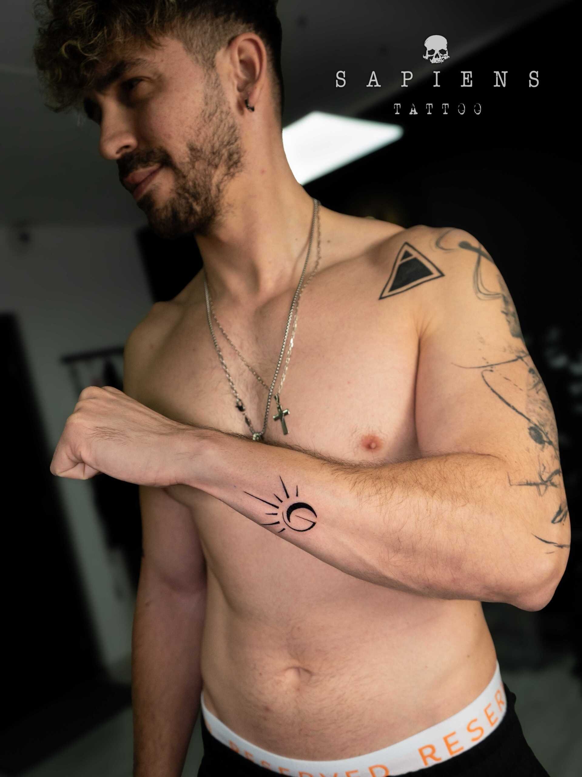 tatuaj pentru baieti realizat pe antebrat exterior cu un simbol de soarele si luna