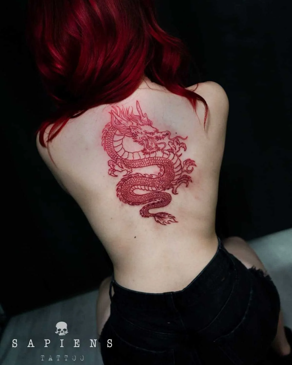 femeie cu tatuaj pe spate realizat integral cu tus rosu