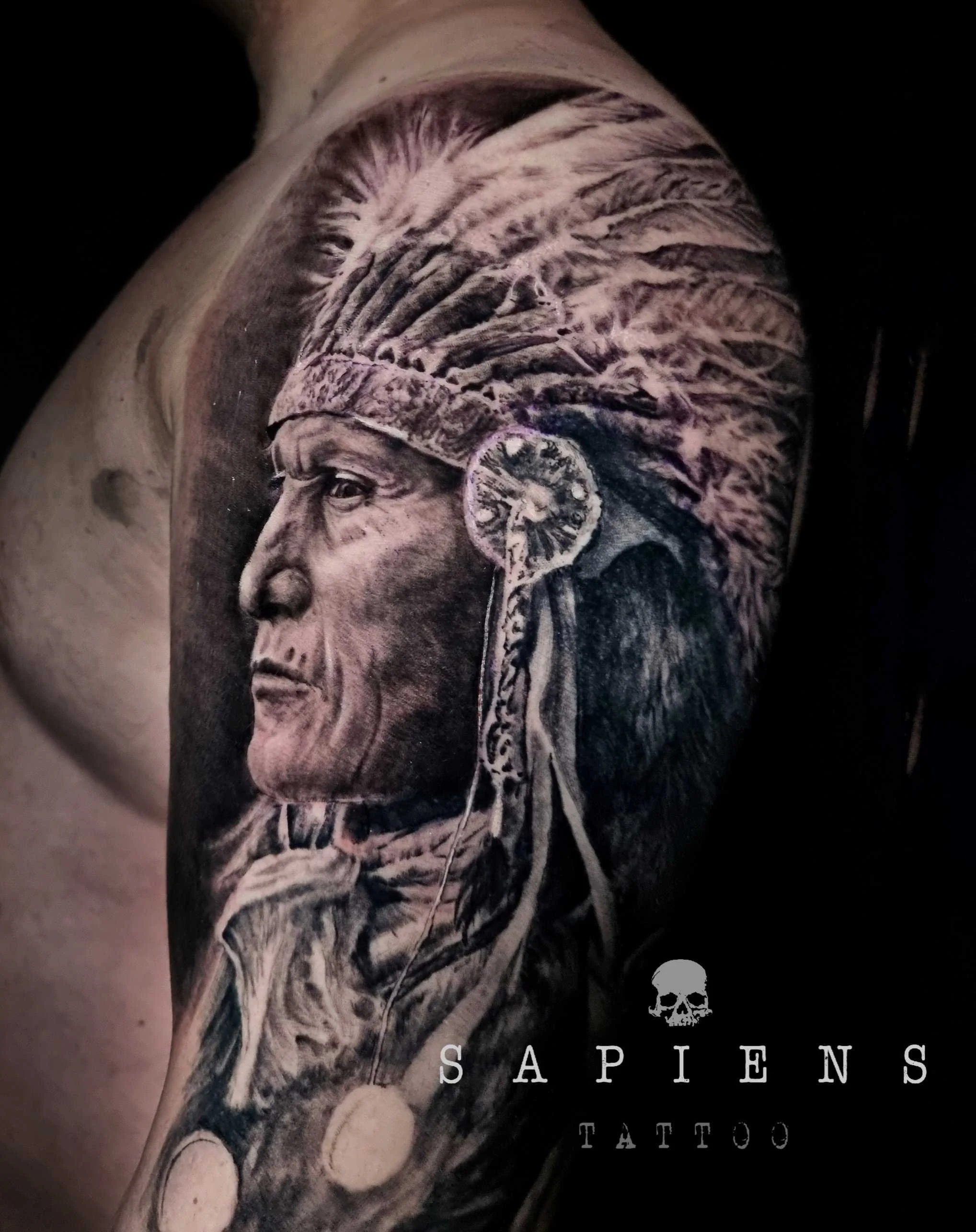 tatuaj mare cu personaj indigen pe bratul unui barbat