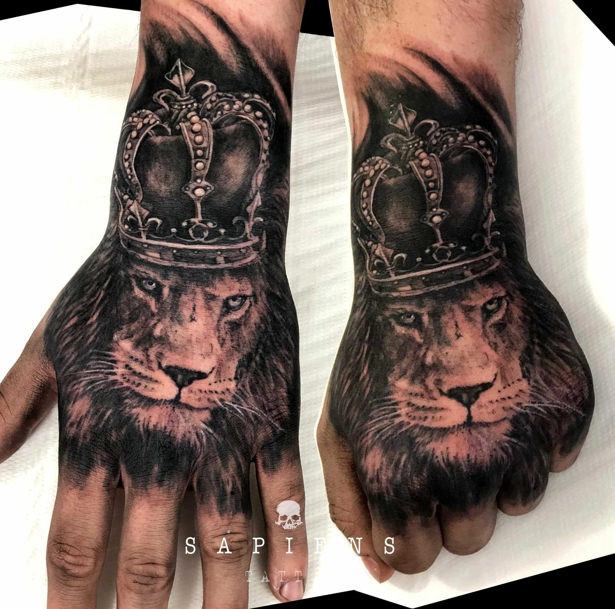 tatuaj pe mana pumn cu leu cu coroana realizat in stil realistic black and gray