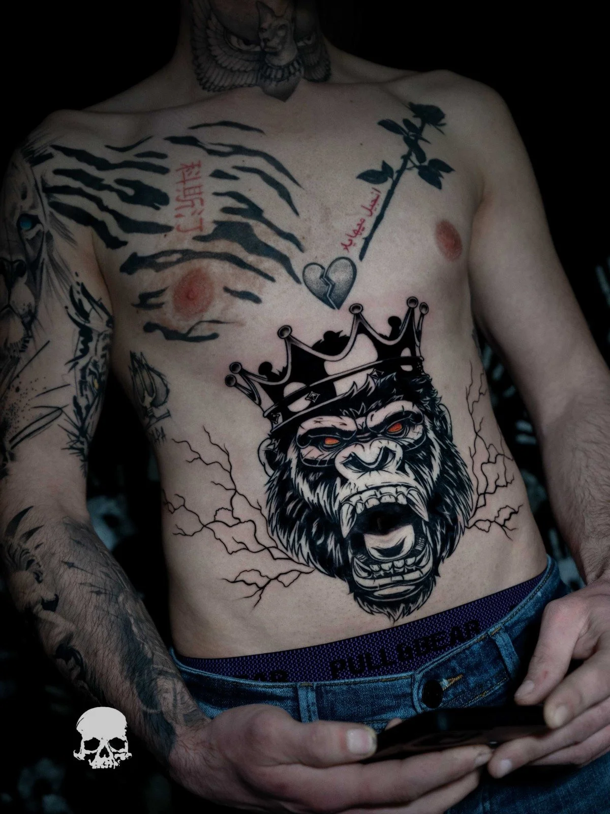 barbat tatuat pe burta cu o maimuta ce poarta o coroana