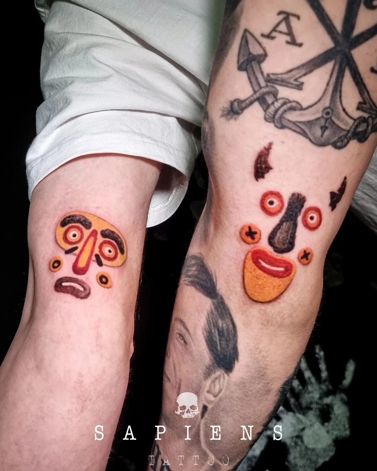 color match tattoo on arm with two masks for two friends