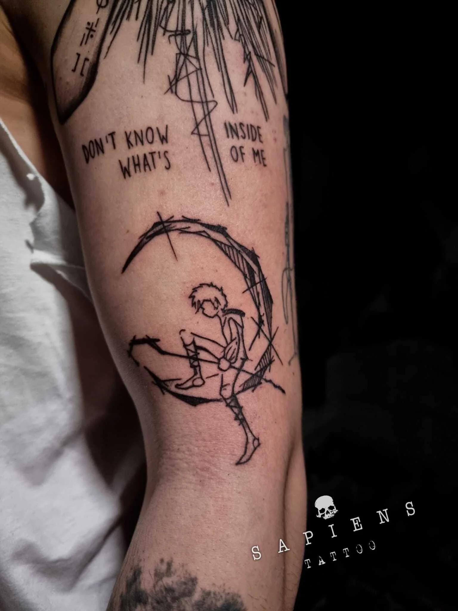 tatuaj realizat in stil sketch cu tus negru pe bratul unui barbat cu perosnajul din peter pan