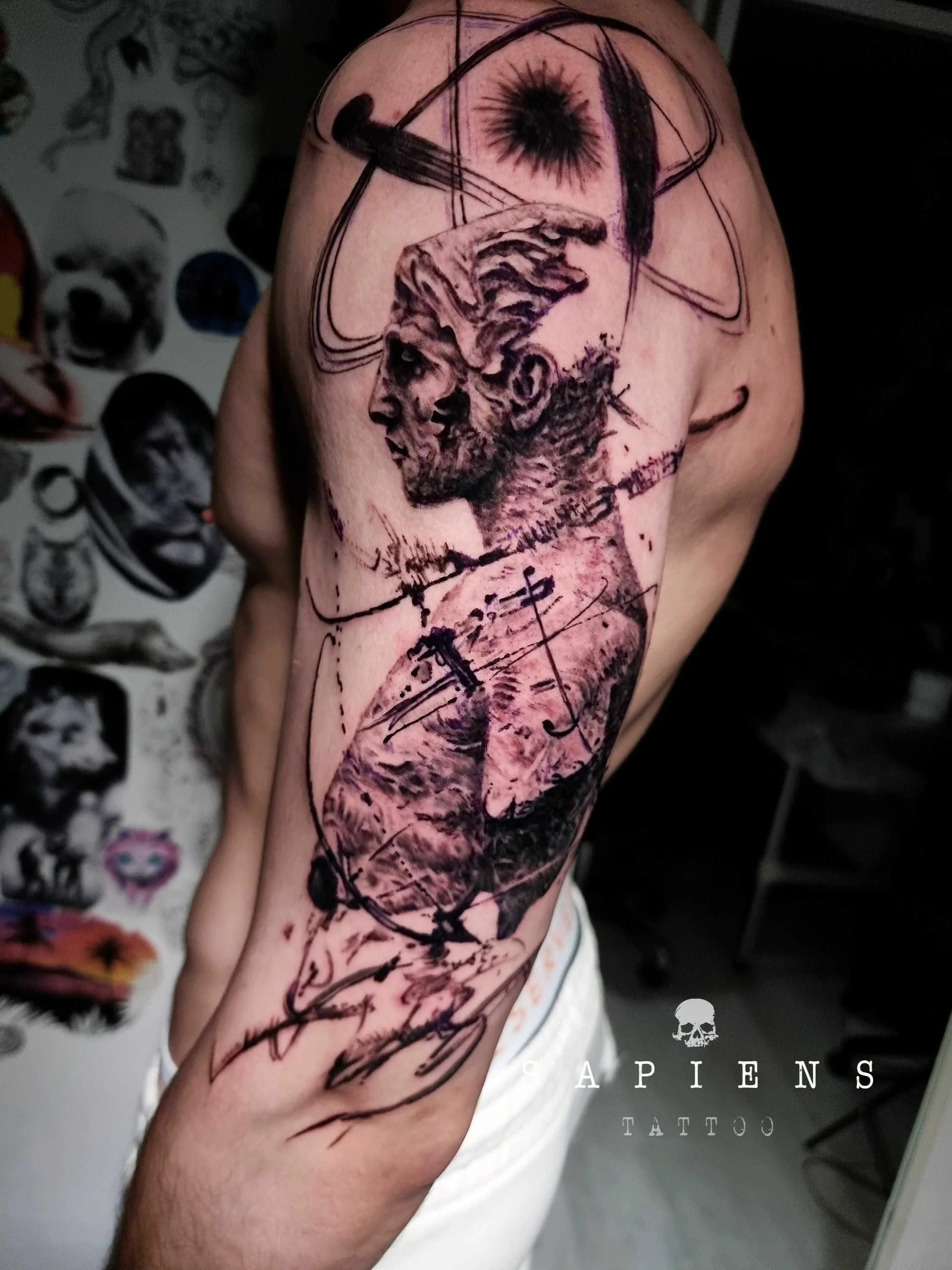 model de tatuaj sketch pe brat de la umar la cot iar pe umar un atom