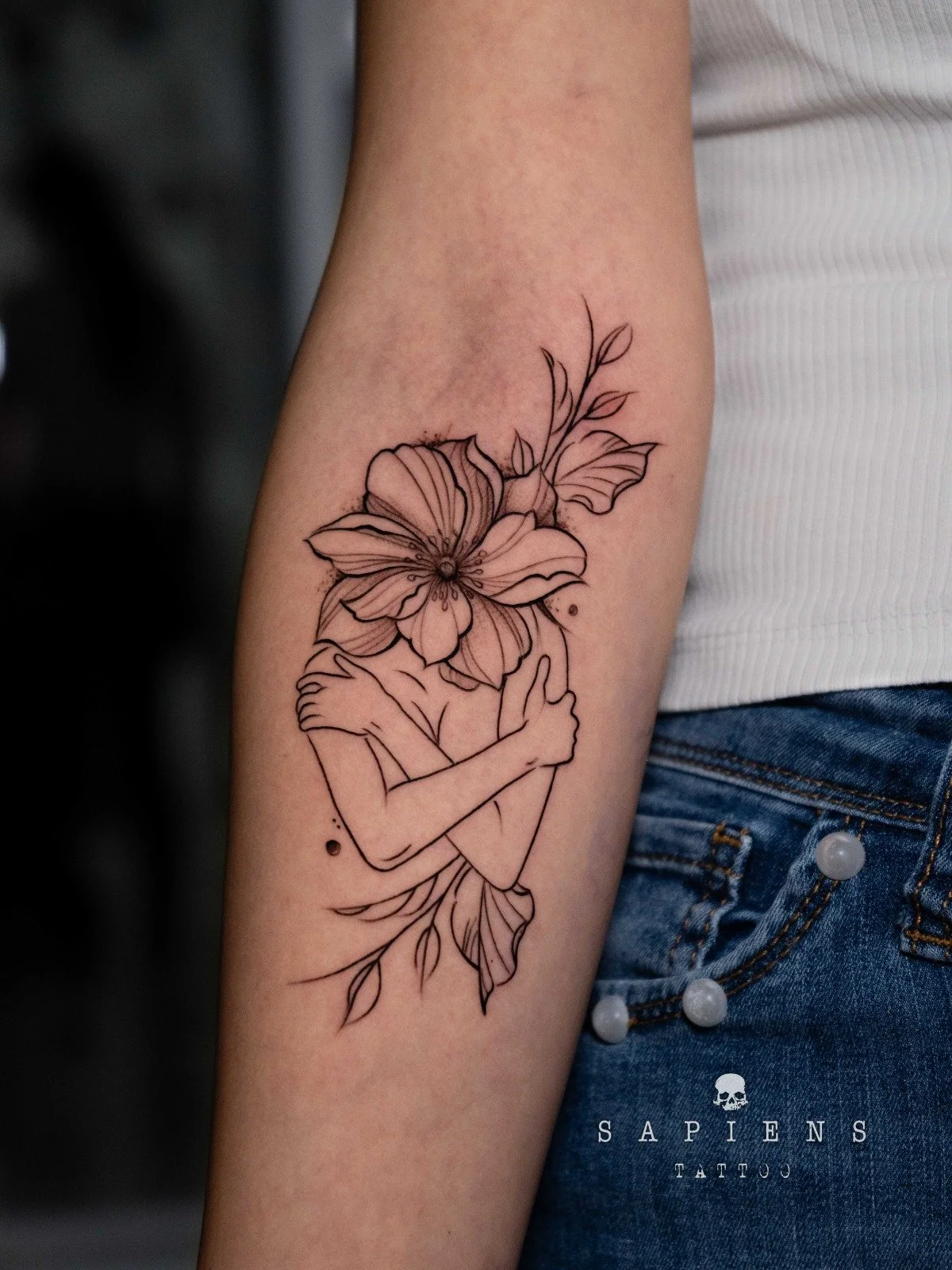 tattoo fine line cu o fata ce se imbratiseaza si ce este inconjurata de flori