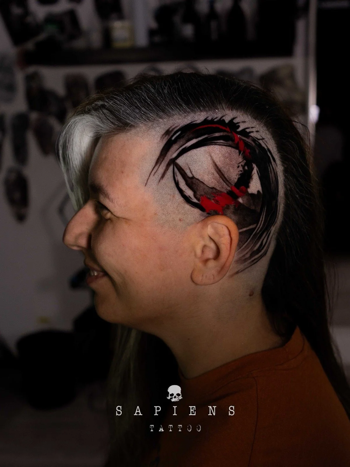 tatuaj pe cap facut in stil abstract cu tus negru si tus rosu pentru o femeie