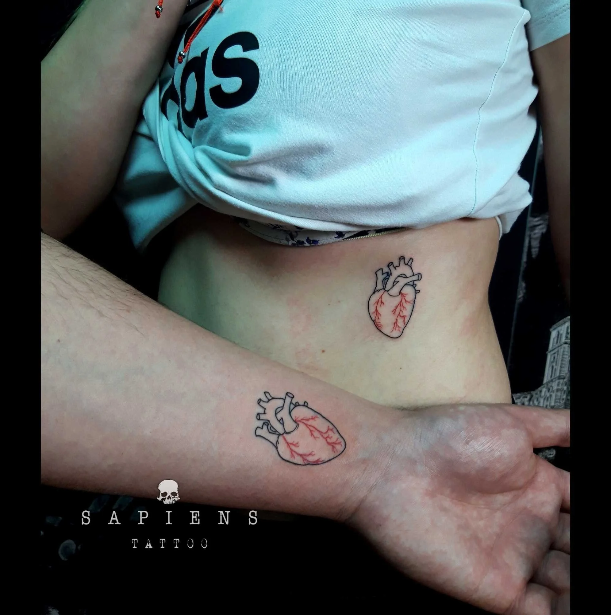 tatuaj de cuplu cu doua inimi cu tus negru si tus rosu