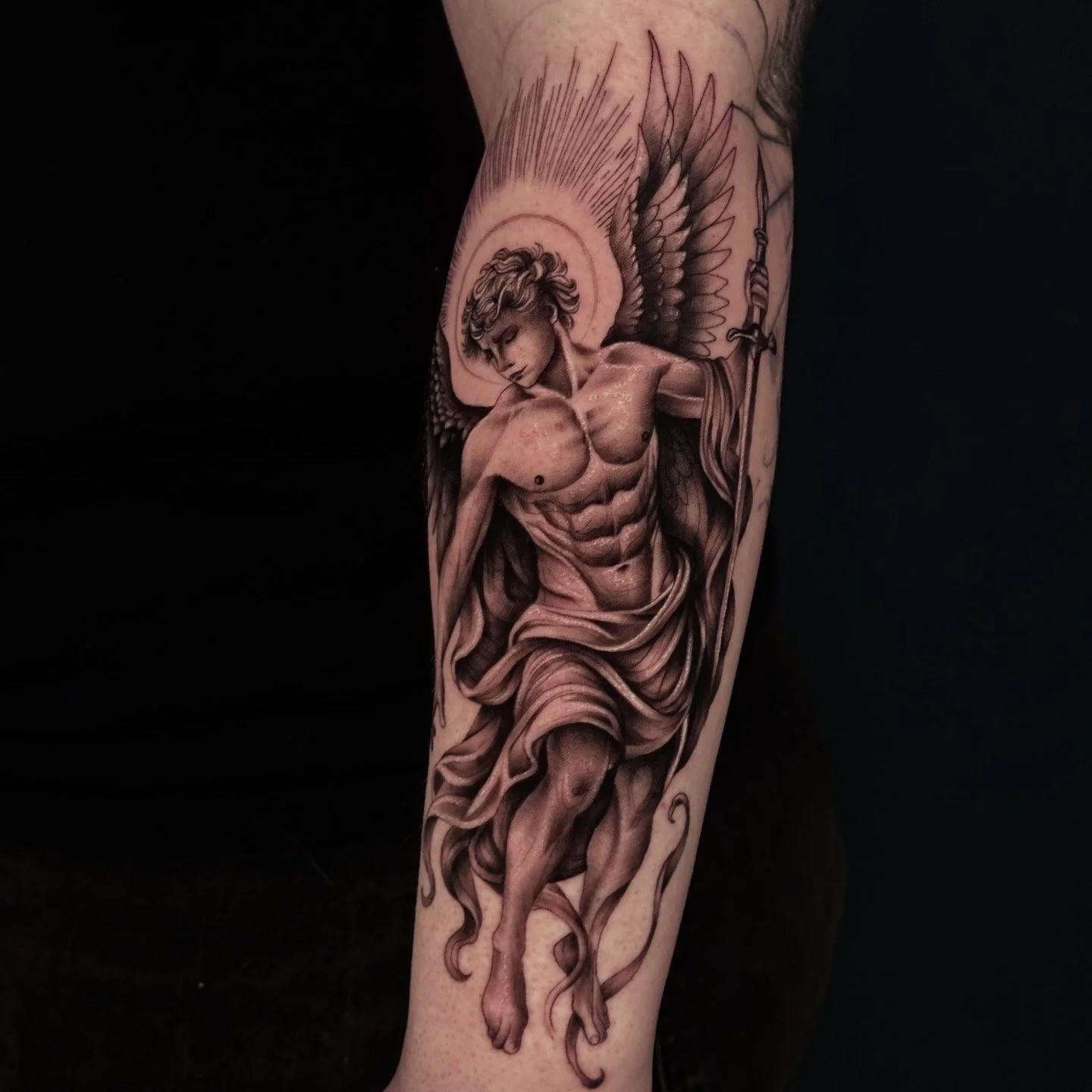 Detailliertes Tattoo eines geflügelten Engels mit einem Bogen auf dem Unterarm.