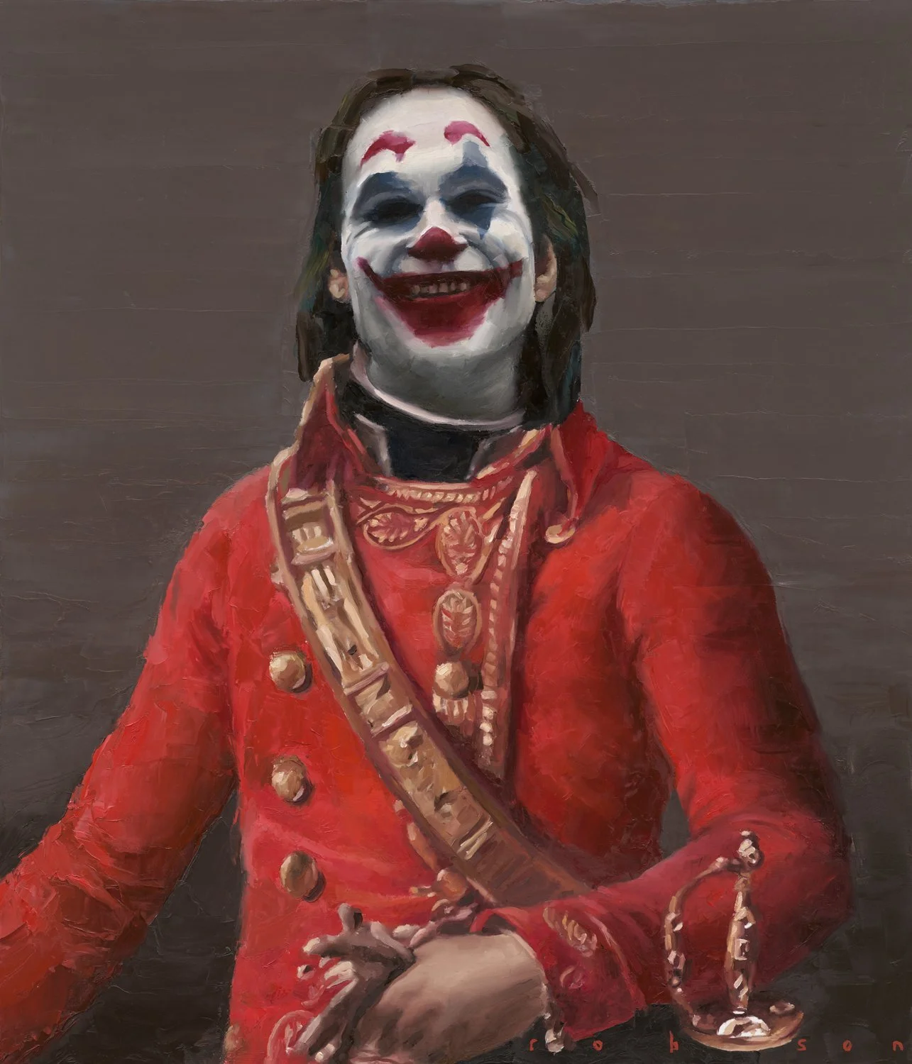 A person dressed as a clown with white face paint, red lips, and exaggerated red and blue makeup, wearing a red jacket with gold buttons and decorative jewelry, smiling with hands clasped, against a dark background.