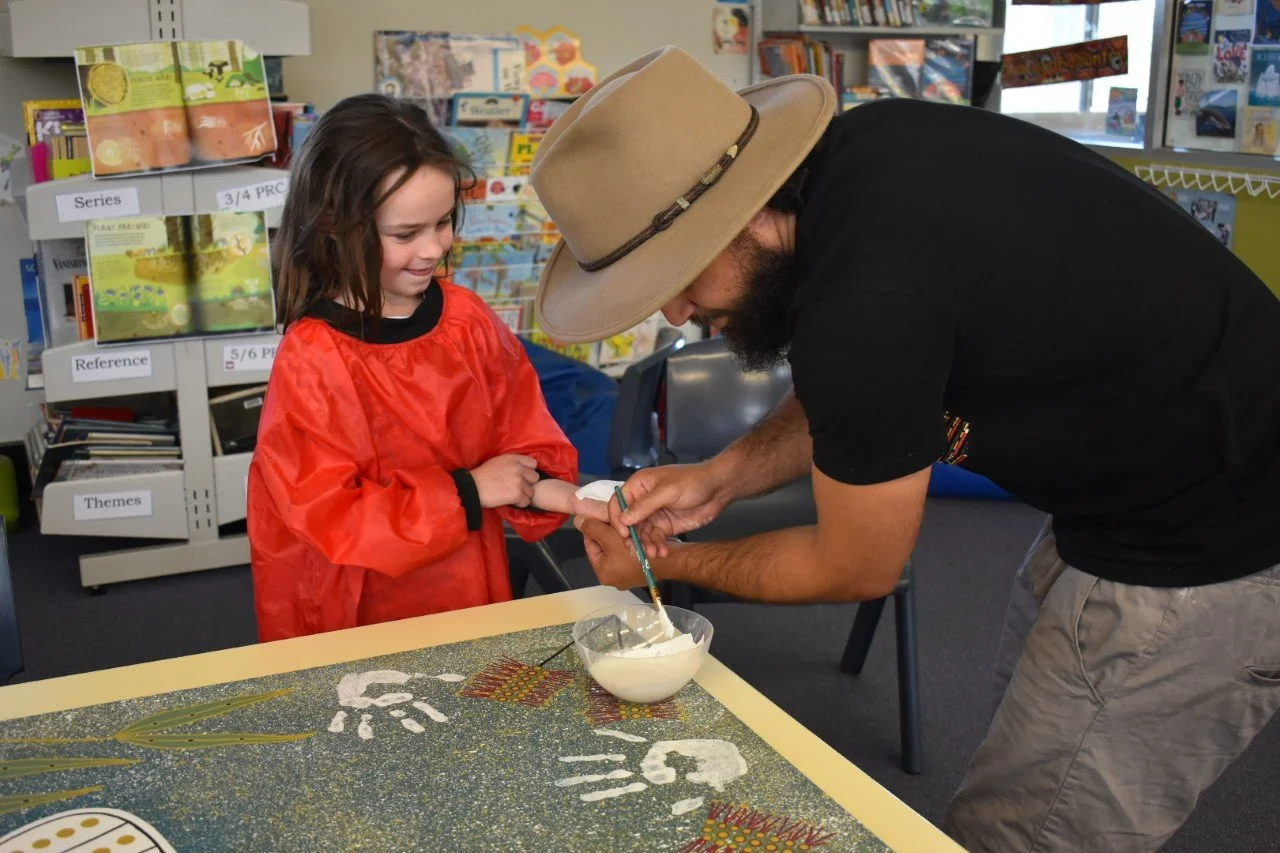 Student creating artwork with guidance from Lyle Ah Sam during a cultural art session