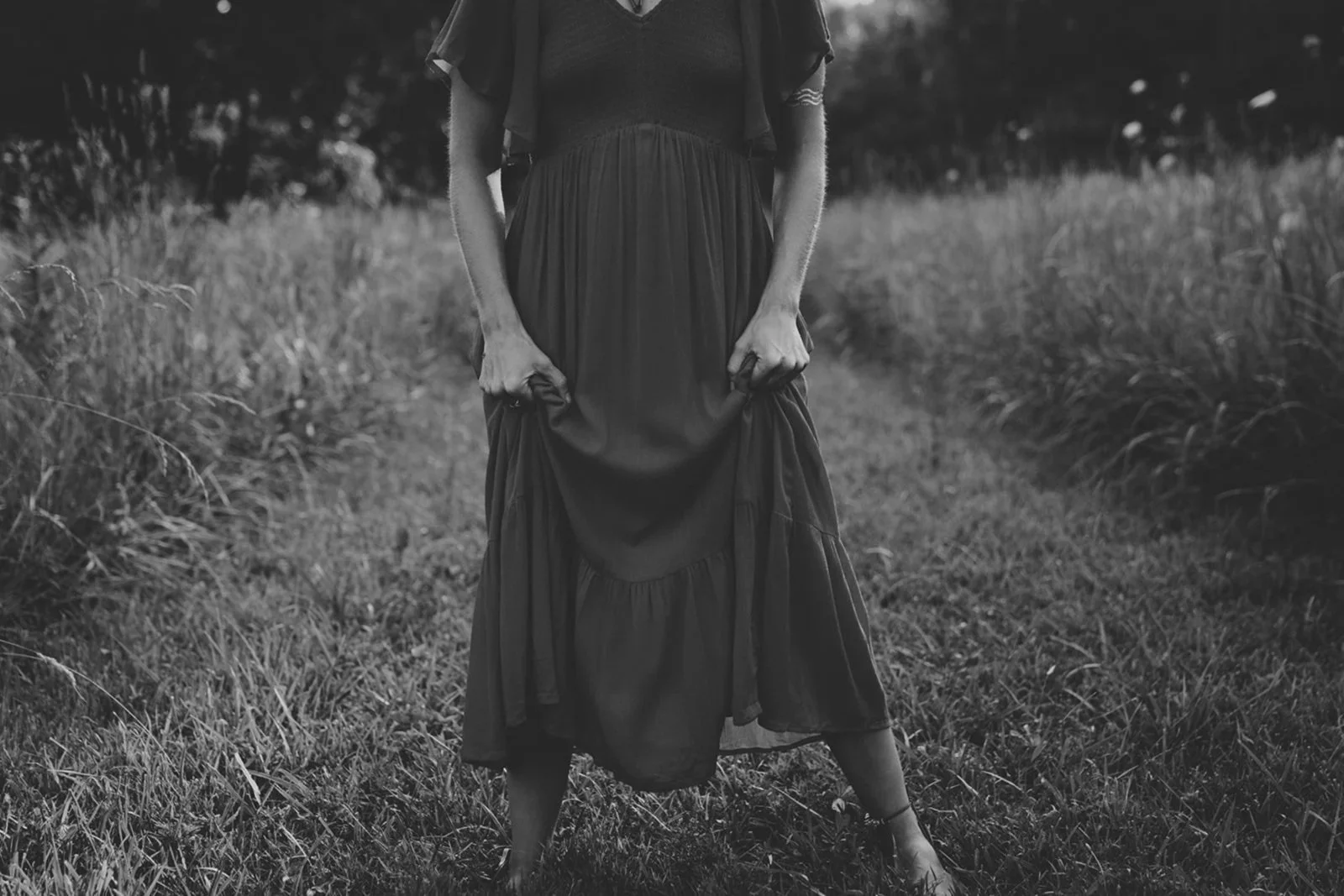 Woman with fists clenching dress - somatic anger