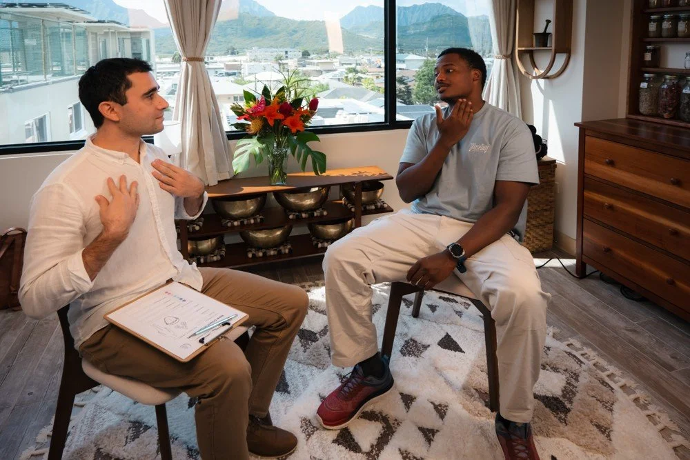 Bryce Delmar speaking with a client during an Ayurvedic assessment at the Kailua clinic on Oʻahu.