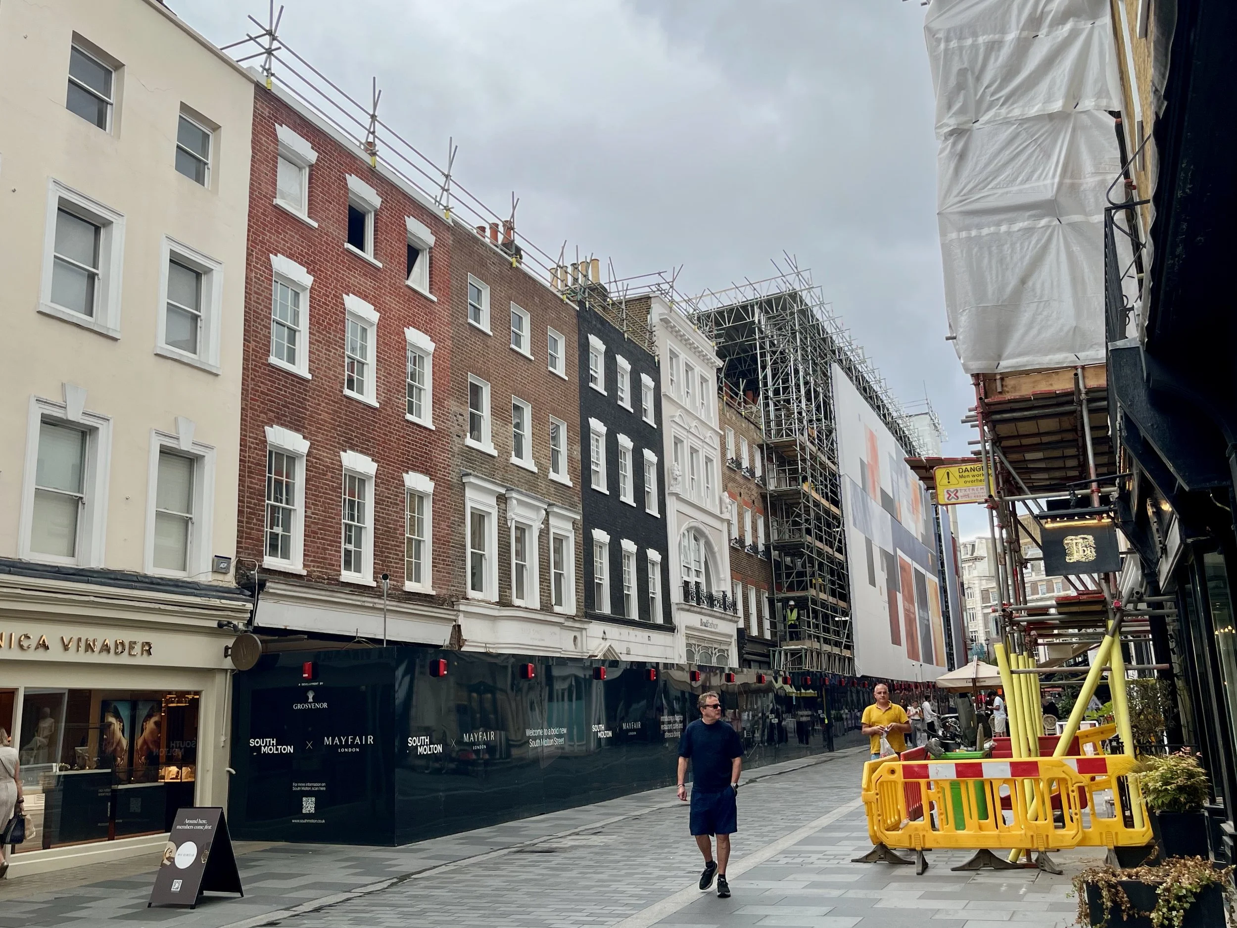 Sarah Earney Architecture & Conservation — A view up South Molton Street, central London, showing a row of Georgian houses with shops at ground floor, in the middle of a regeneration project.