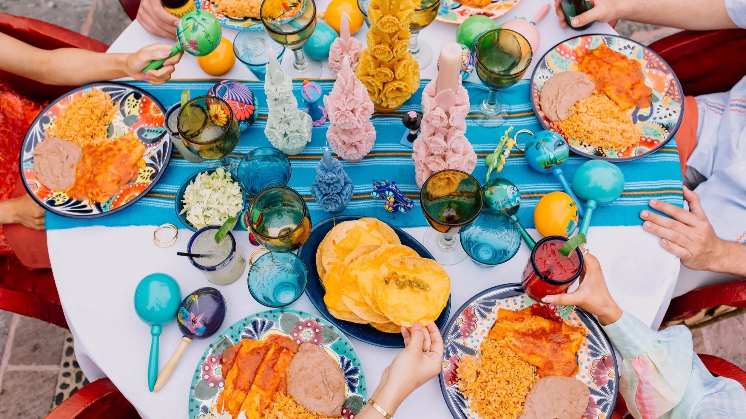 A colorful table of Joe T's food and margaritas