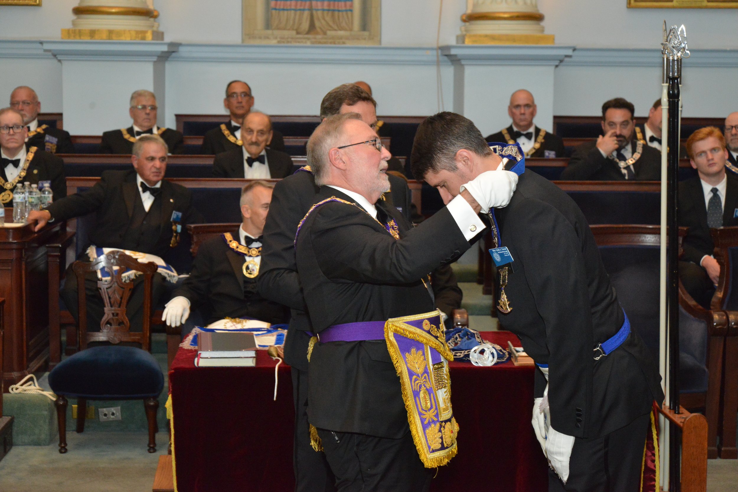  The Grand Secretary, Most Worshipful Richard Maggio, investing the Secretary, Wor. Colin Turner, with the jewel of his office, the Crossed Pens 