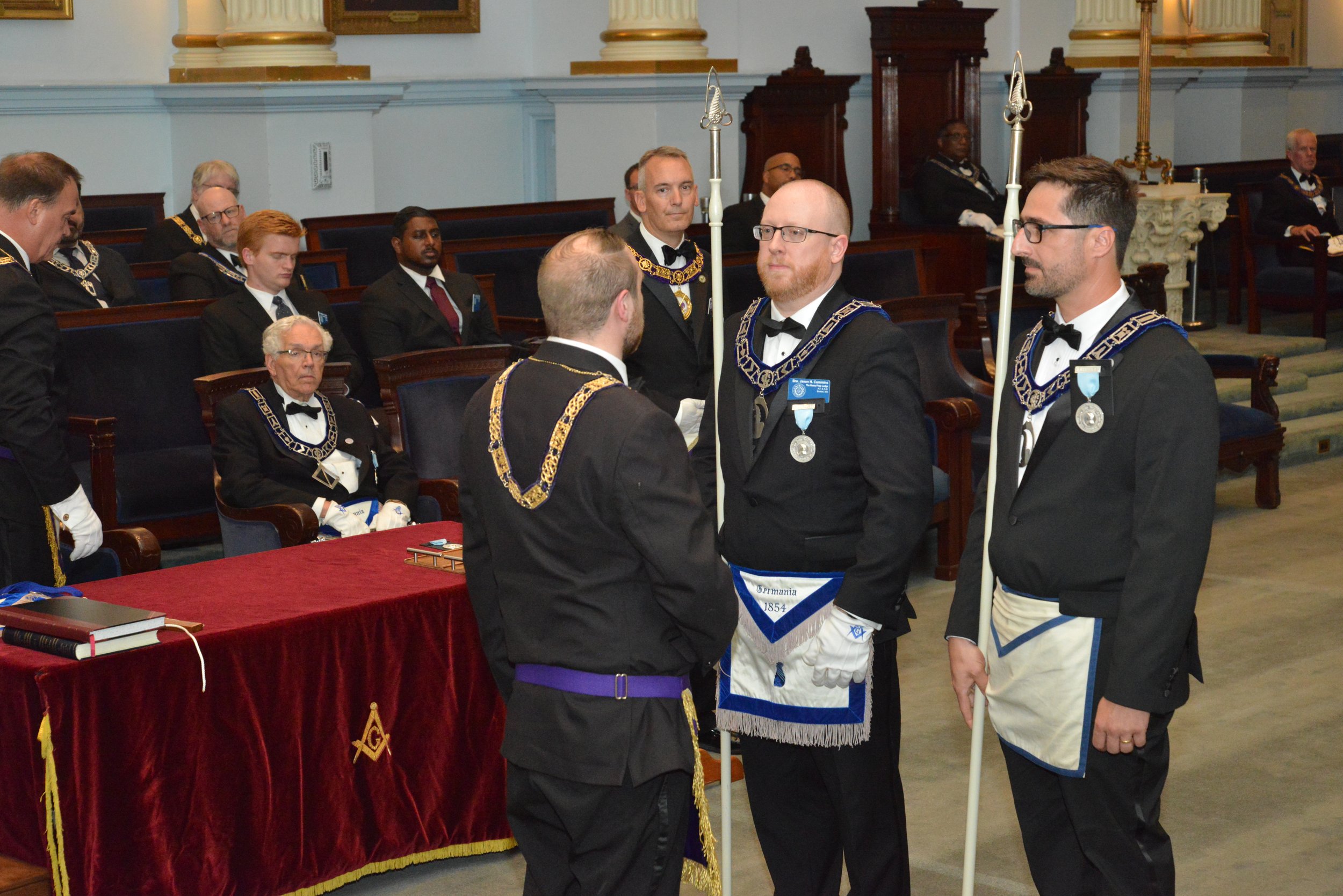  The Grand Steward investing the Senior Steward, Bro. Jason Cummins, and Junior Steward, Bro. Udson DaSilva, with the jewels and staves of their office 