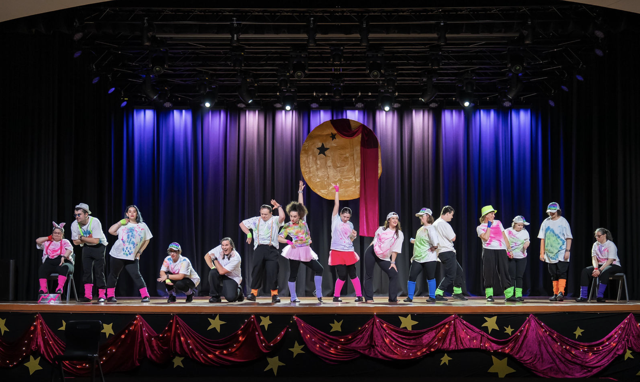 Annual Mid Year Show, members in fluro costume and posing on stage